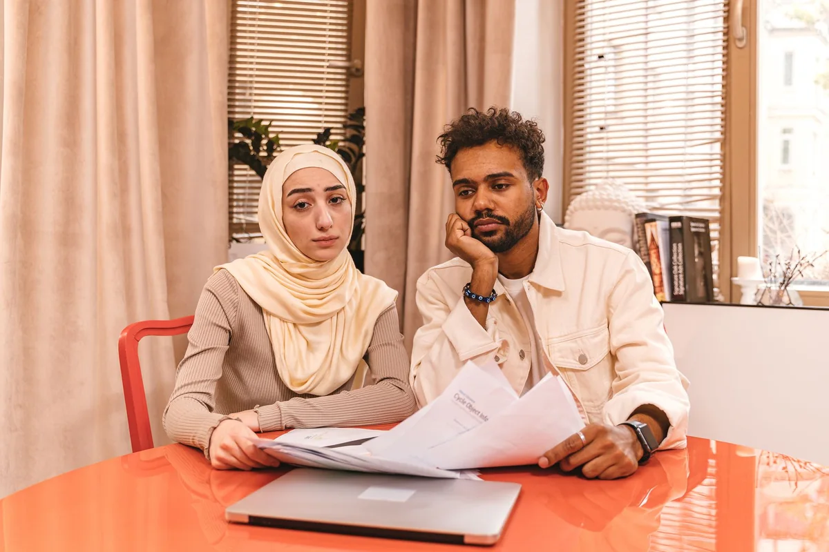 Couple at a kitchen table deciding whether to sell to a cash buyer