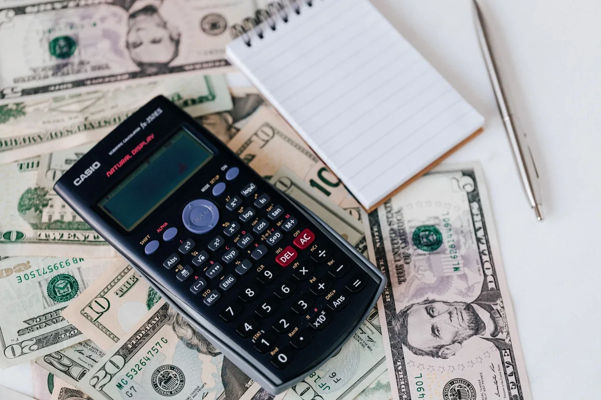 Calculator and cash showing how a we buy houses offer is calculated
