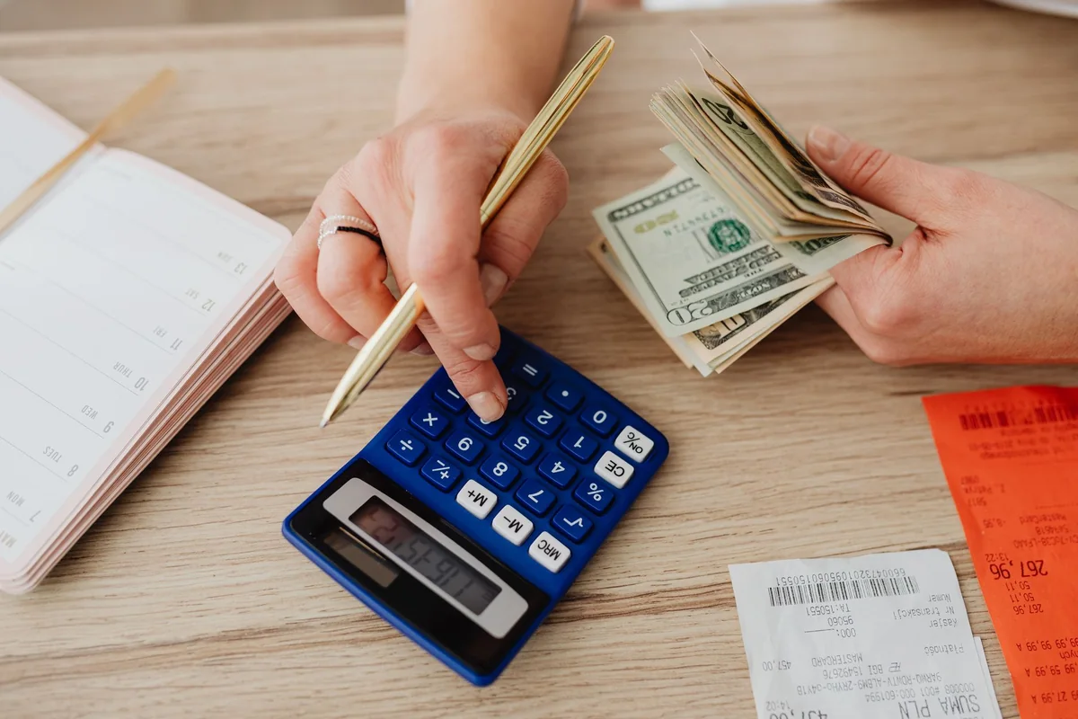 A calculator and paperwork tallying the real costs of selling a house