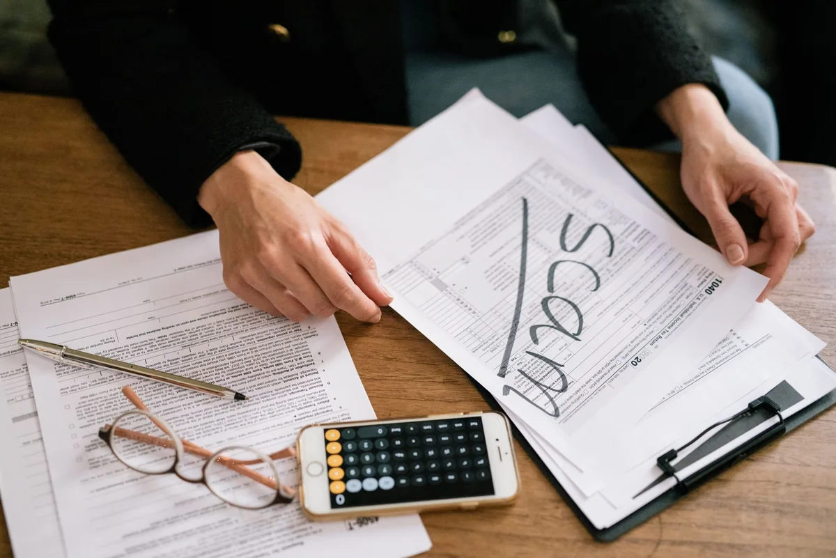 Tax forms and a calculator on a desk, the property tax information needed to sell a house for cash in Iowa