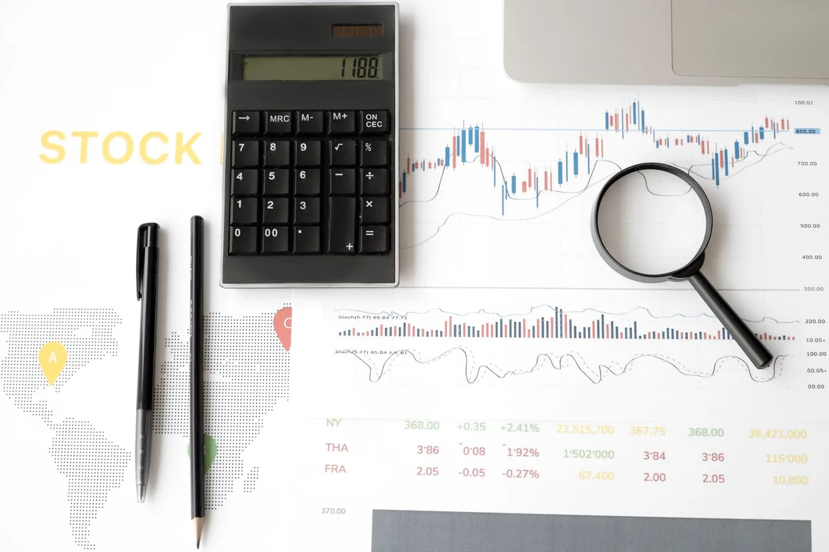 A calculator and paperwork used to reprice a house that won't sell