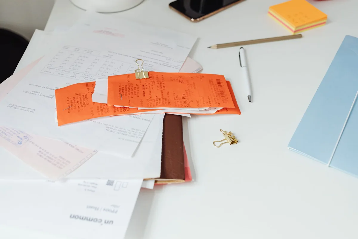 A stack of documents and folders on a desk, the Iowa abstract of title that affects how fast you can close on a cash home sale