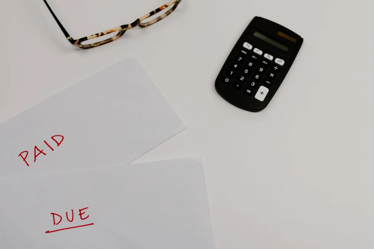 Estate paperwork and unpaid bills spread on a table after inheriting a house with debt