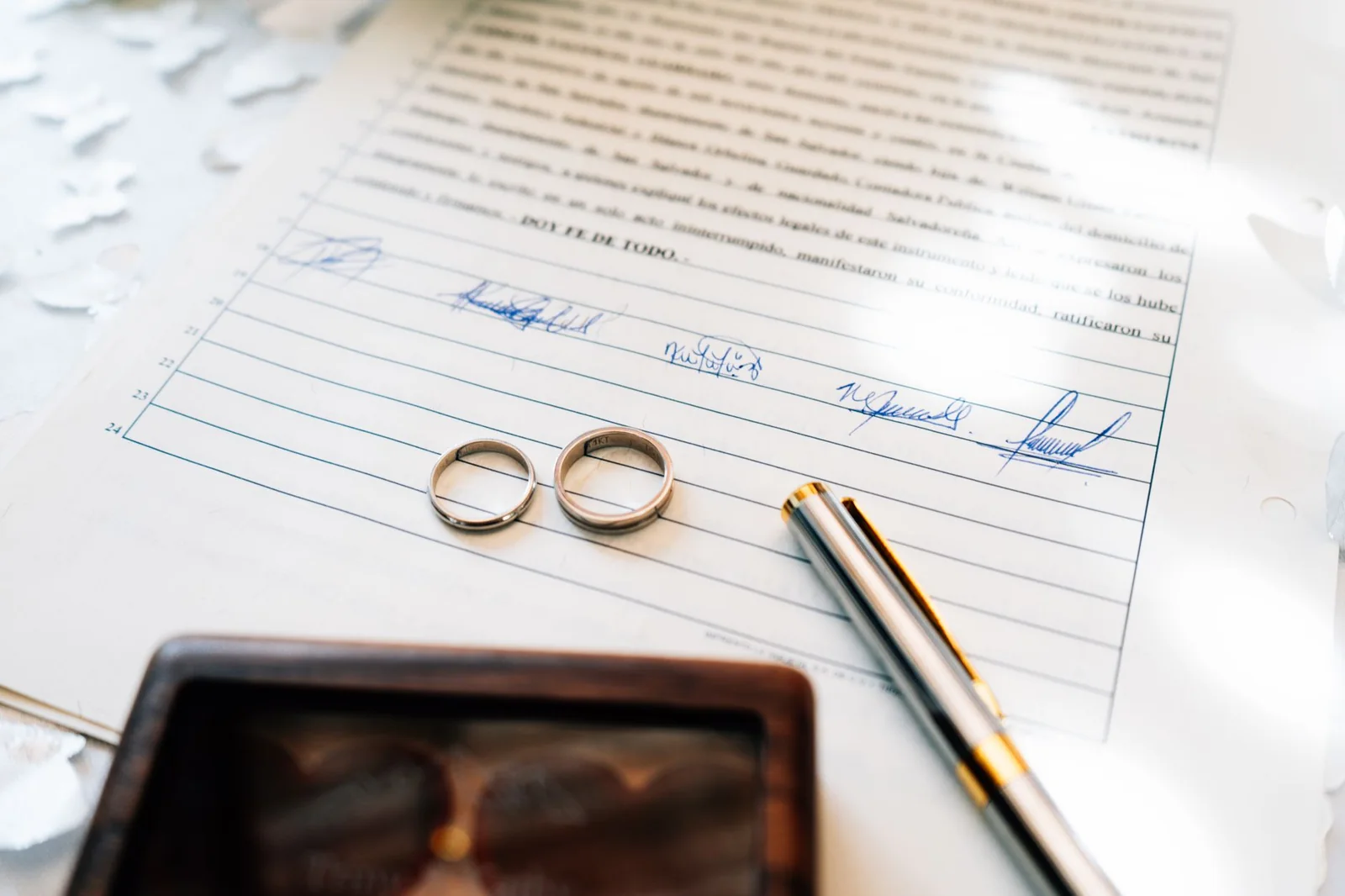 Wedding rings on legal documents during an Iowa divorce home sale
