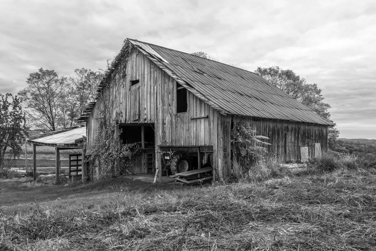 An old wooden barn and outbuilding on a rural property, structures that complicate acreage financing