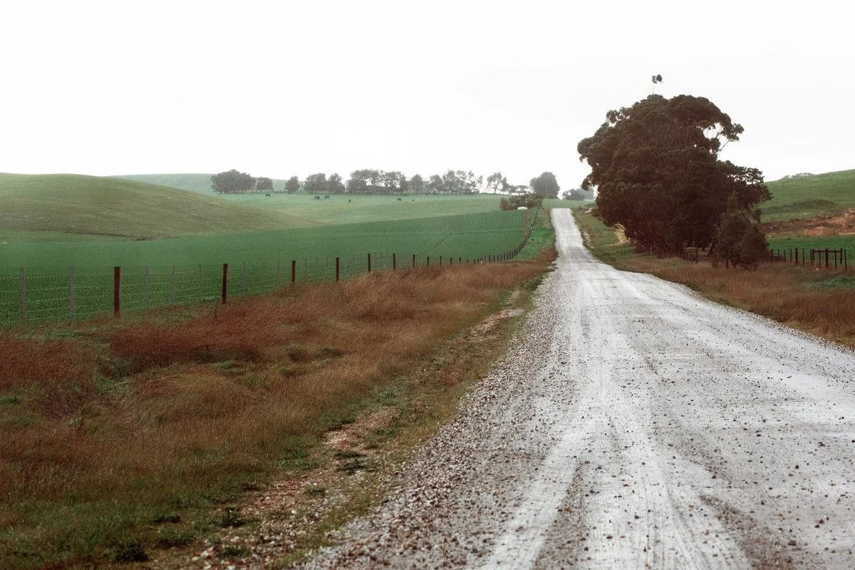 A gravel country road running through rural Iowa farmland, the kind of access that affects selling an acreage