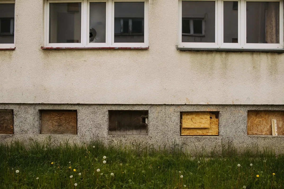 Boarded and broken windows on a building tagged unfit for occupancy