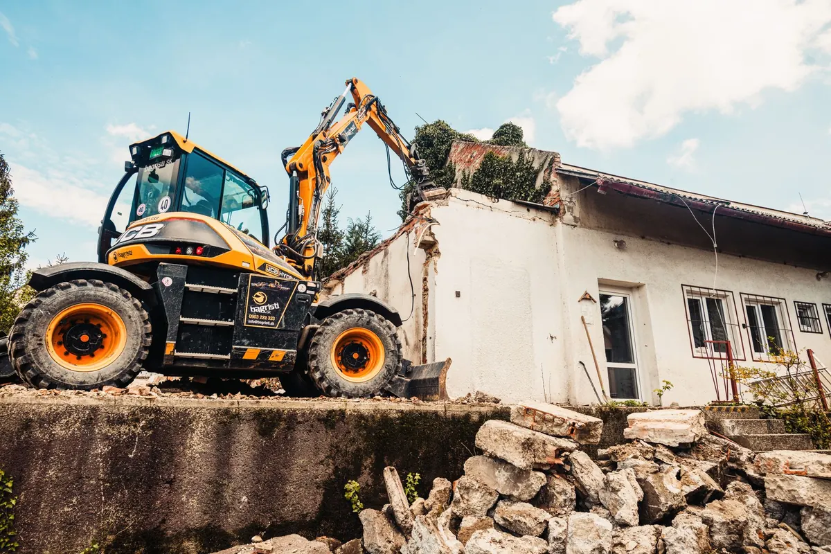 An excavator demolishing a house, one option for a condemned property in Iowa