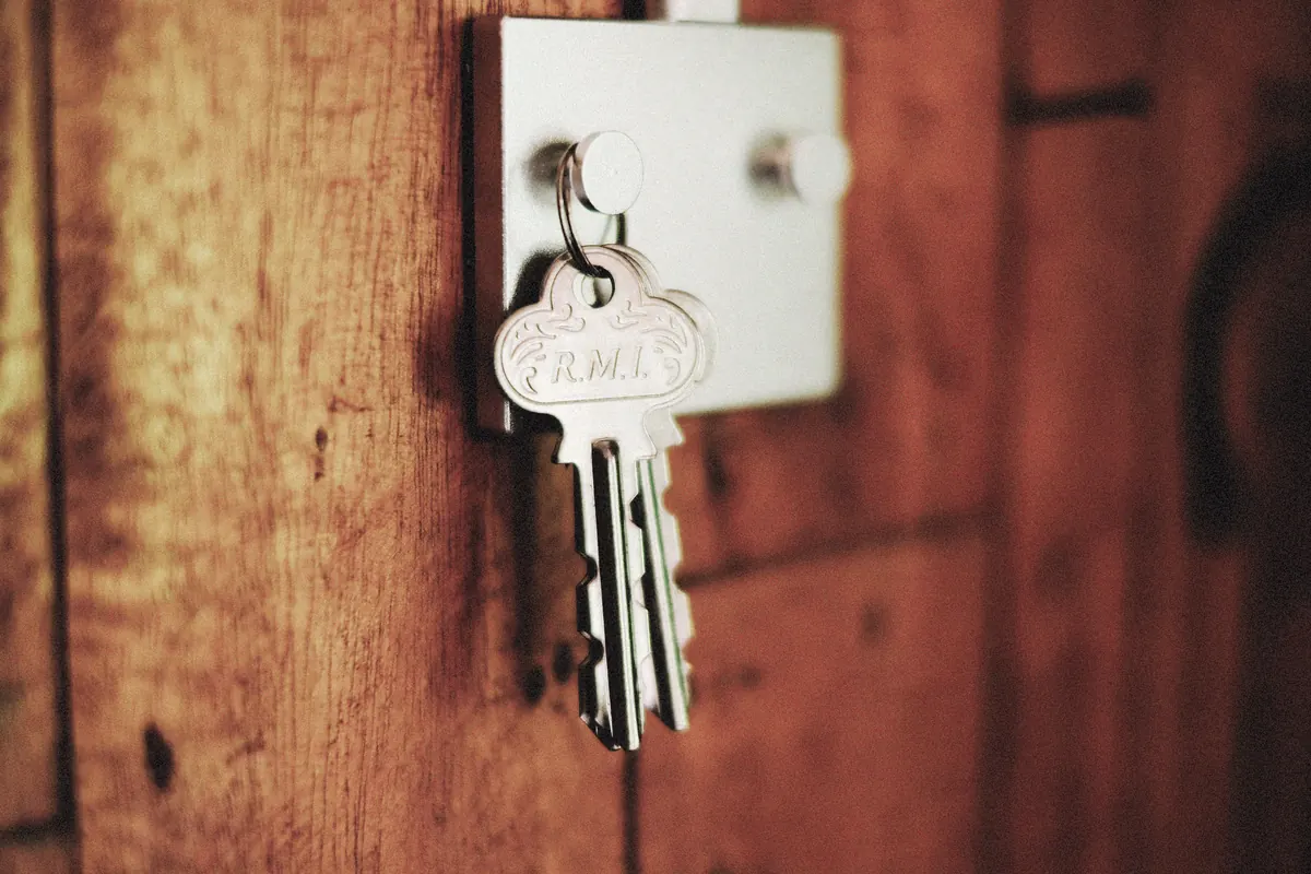 House keys in a door lock, handed from seller to buyer at closing