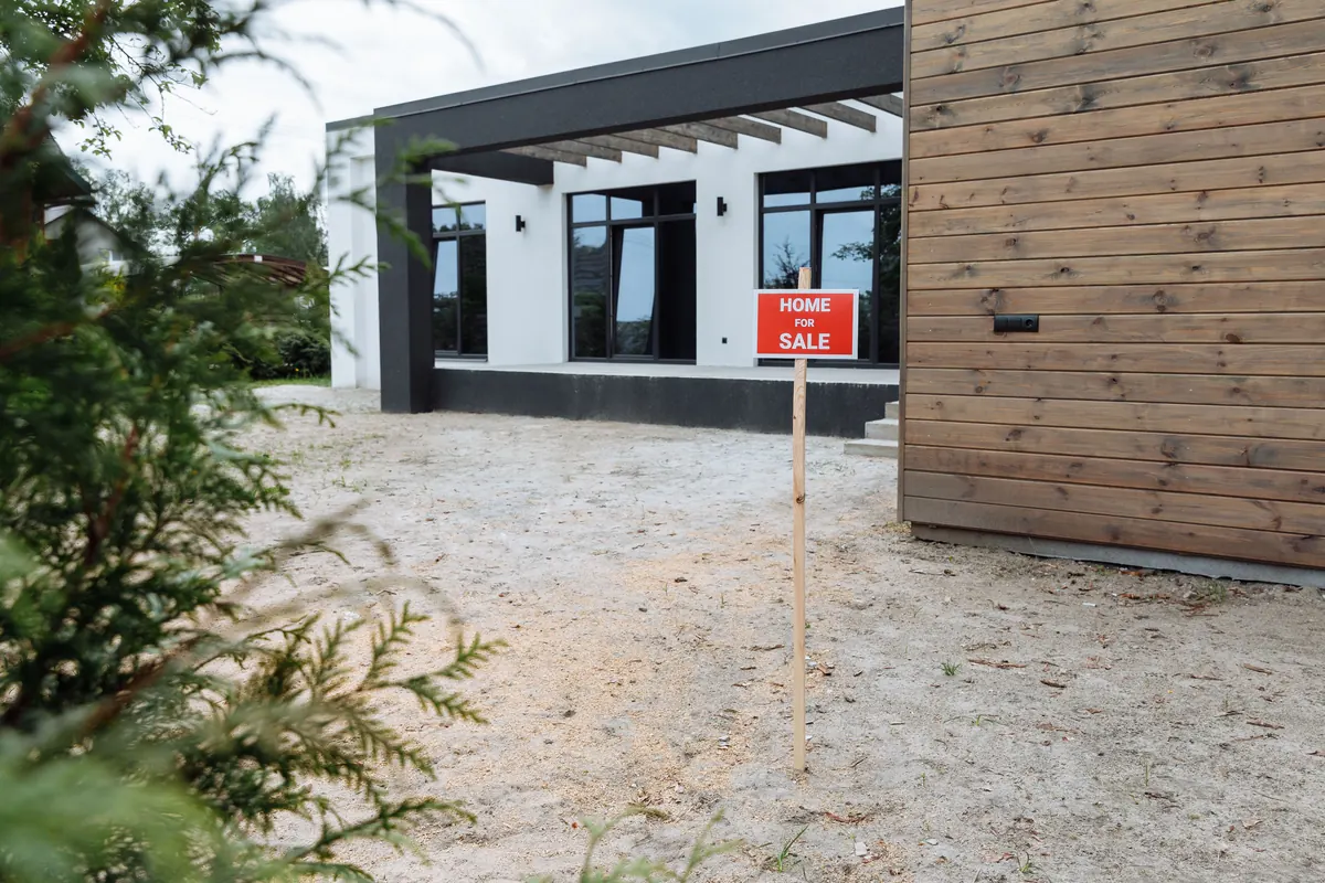 A house with a for-sale sign in the yard, priced with open code violations