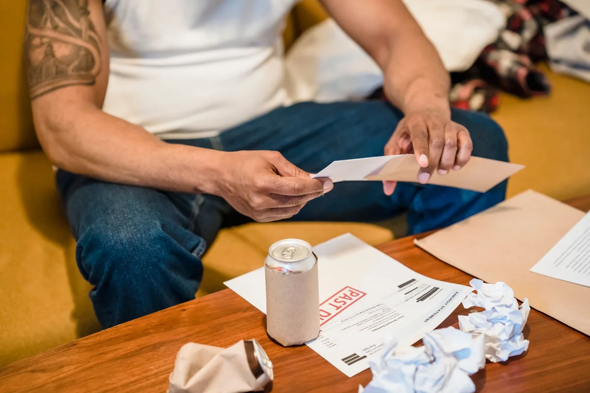 A stack of unpaid property tax bills and envelopes on a table