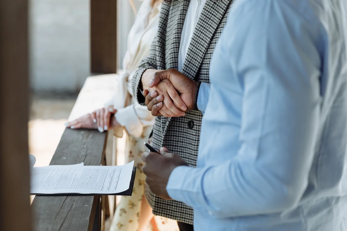 A handshake closing a fast cash sale on an Iowa house with delinquent taxes