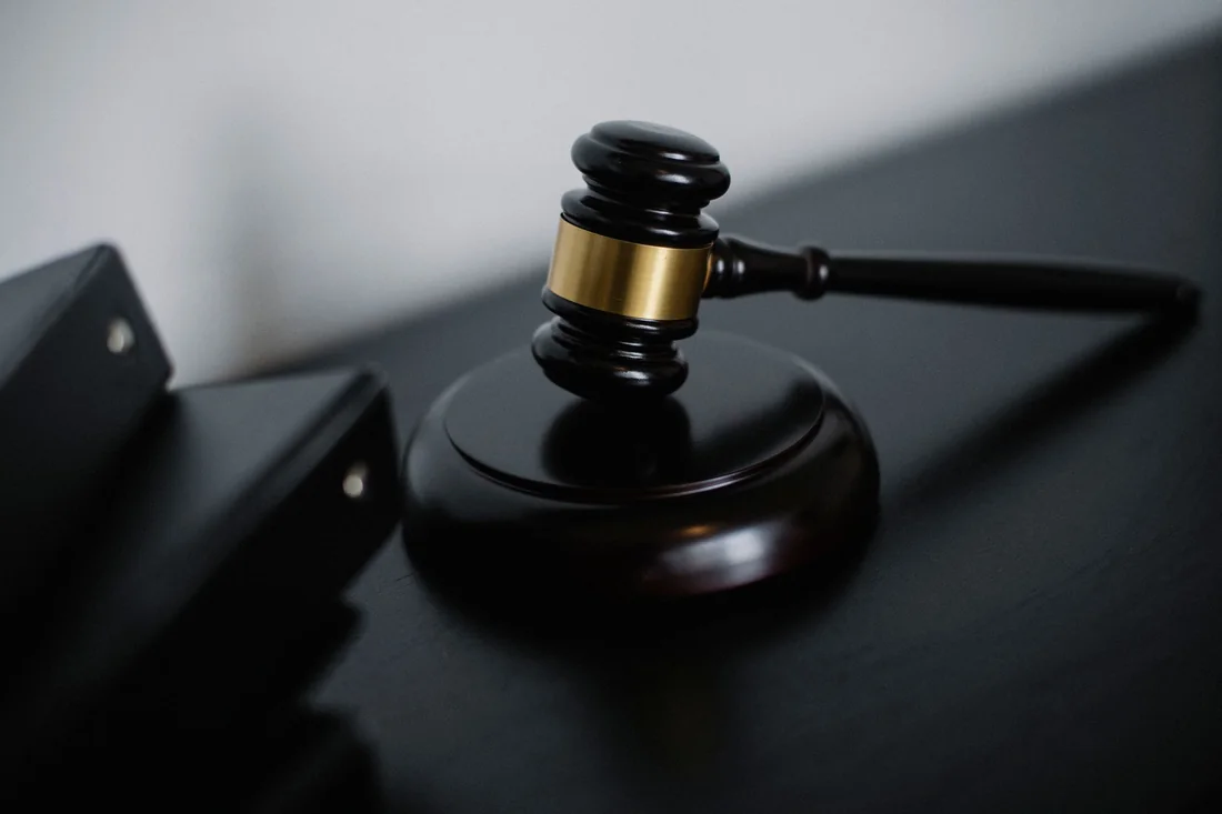 Law books and a wooden gavel, representing the bankruptcy court and trustee involved in selling a house during Chapter 7 bankruptcy in Iowa