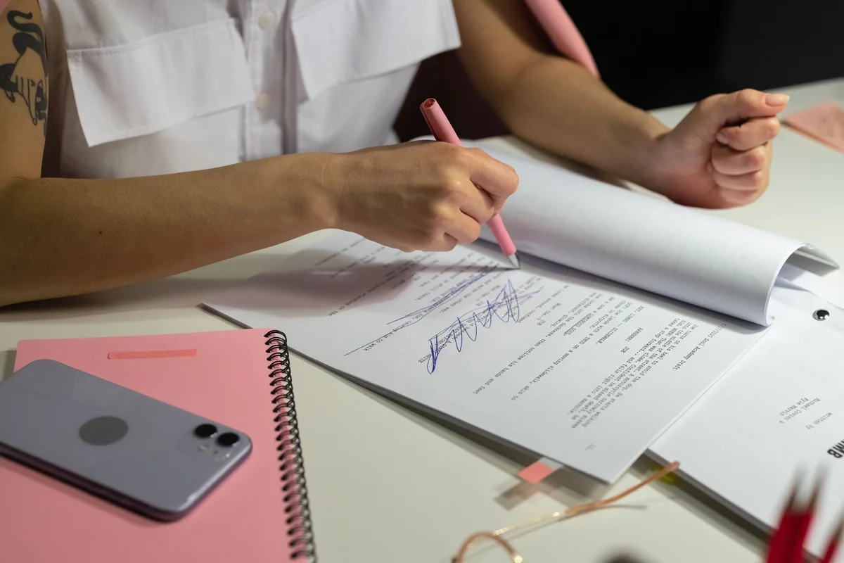 A person writing notes over documents, preparing to dispute a low home appraisal