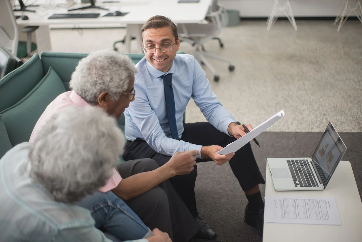 A couple reviewing paperwork at a table with an advisor, weighing options after a low appraisal
