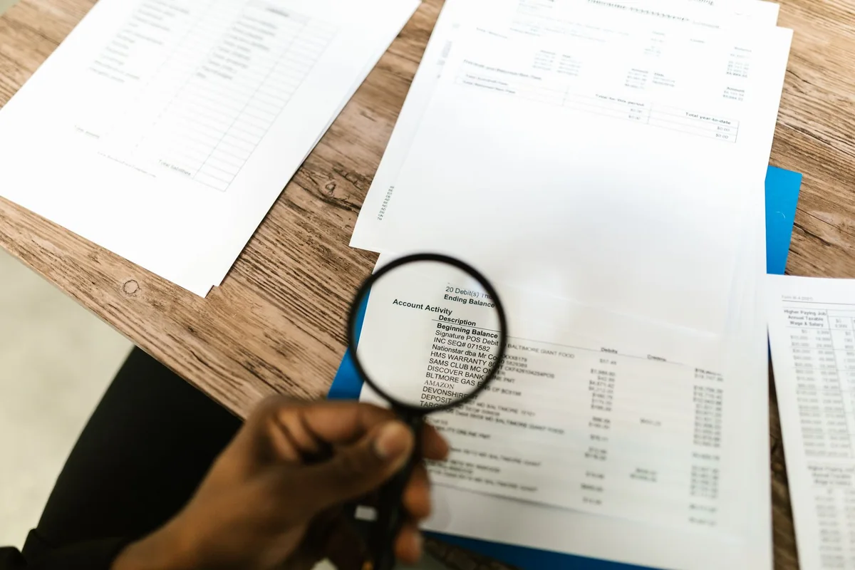 A magnifying glass over a home inspection report, which is a buyer's opinion, not a pass or fail