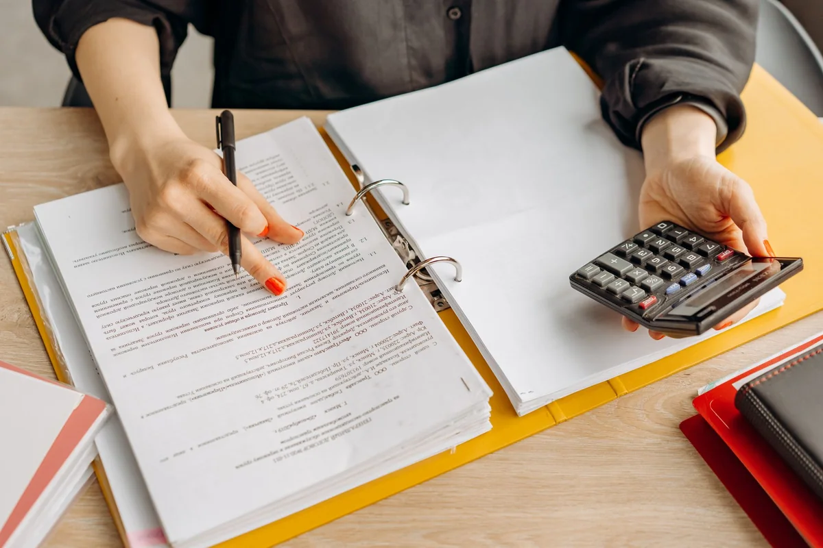 A calculator and paperwork, showing how a cash buyer prices a failed-septic house