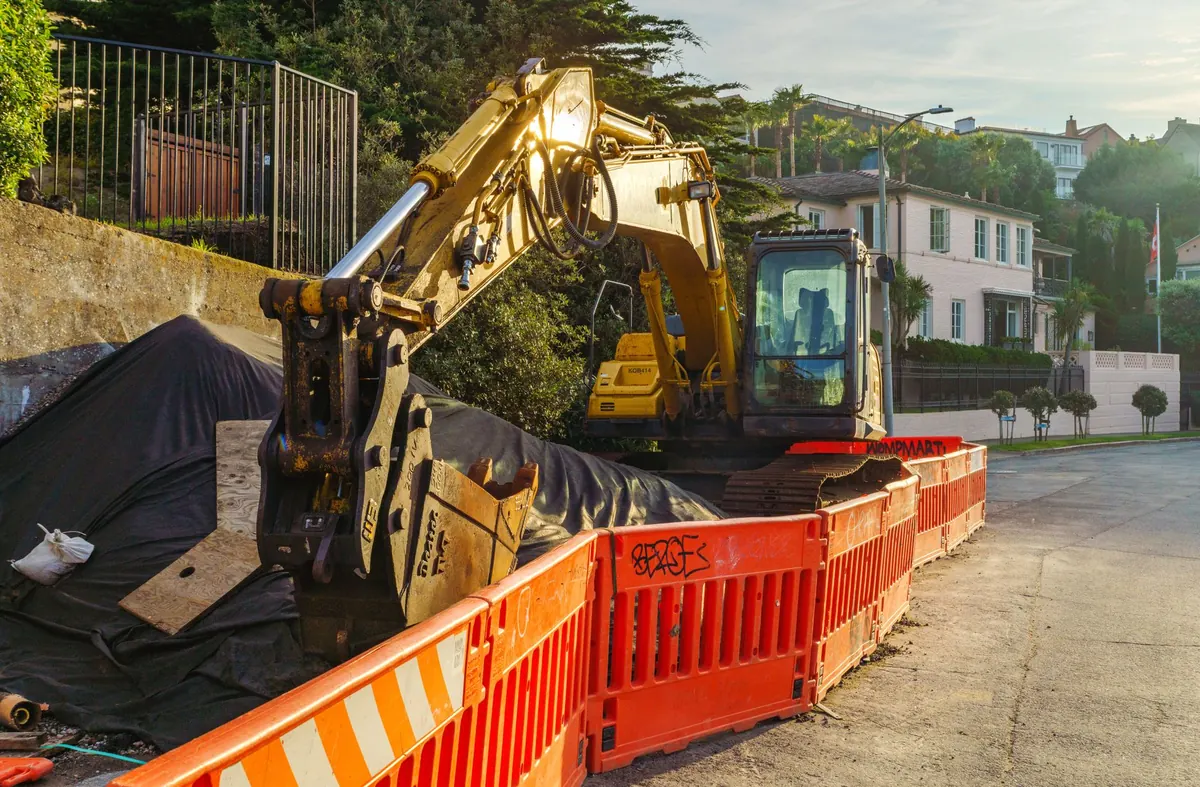 An excavator on a job site, representing the option to repair or replace a failed septic