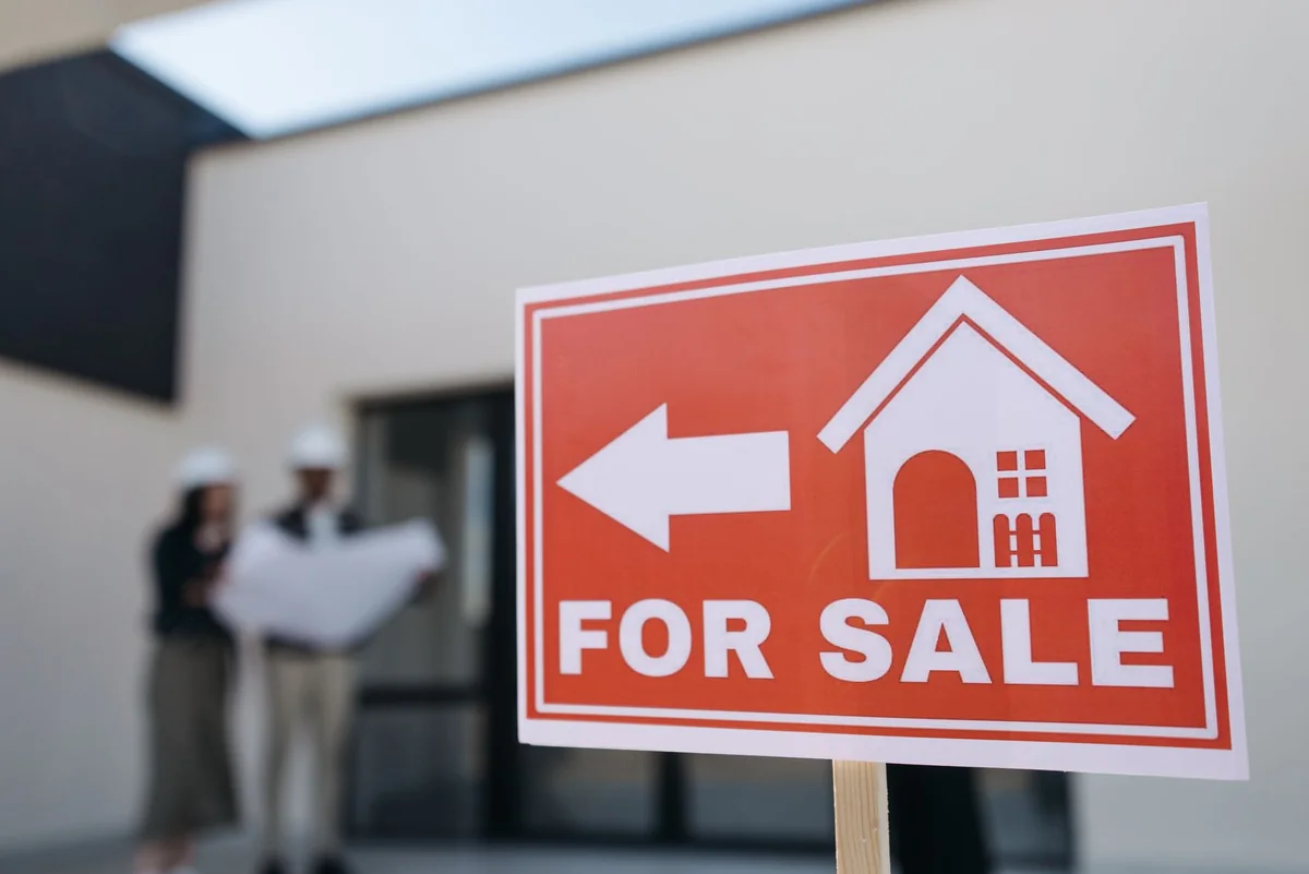A for-sale sign in front of a house with foundation problems in Iowa