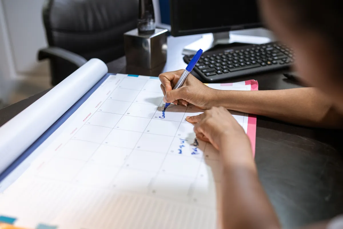 A person marking a calendar while planning a home sale around a job relocation