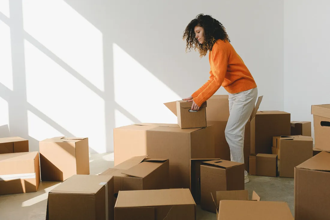Moving boxes stacked in a room while selling a house for a job relocation in Iowa