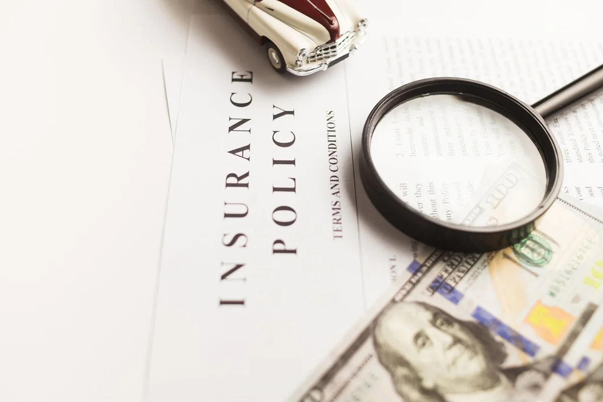 An insurance policy under a magnifying glass, checking what water damage is covered