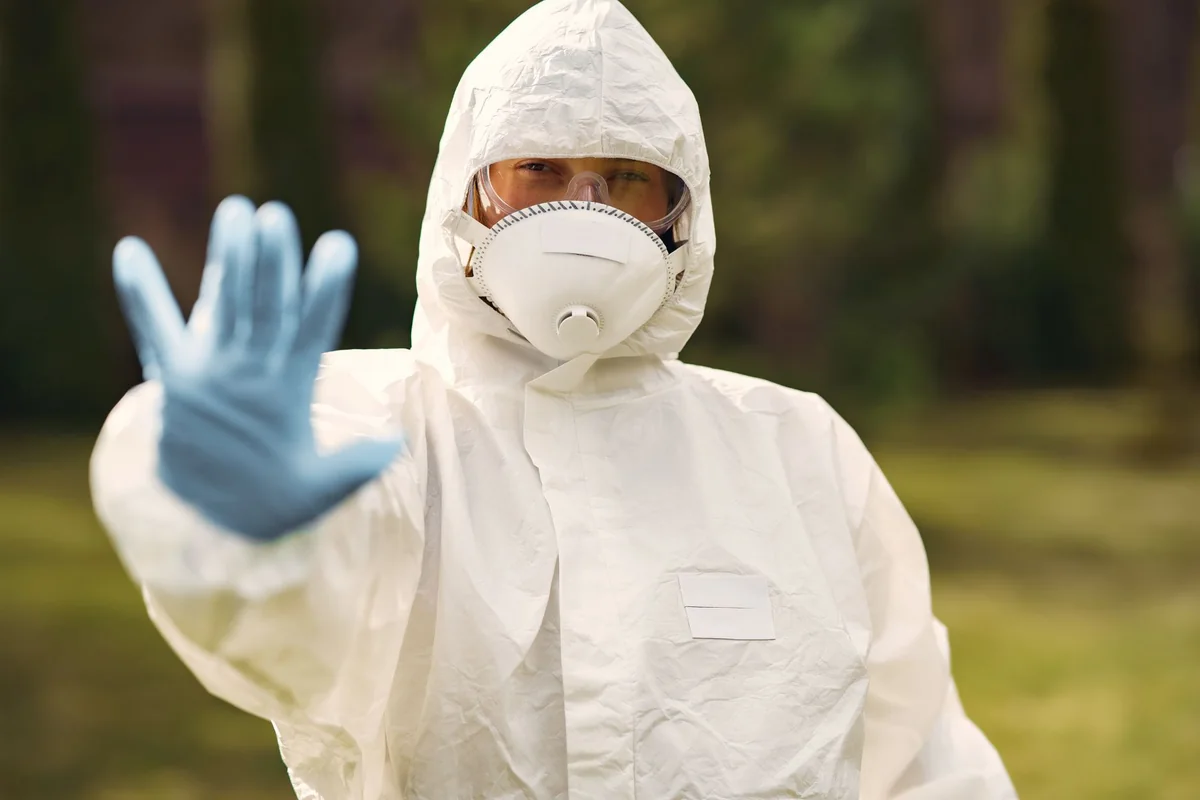 A licensed abatement worker in a protective suit removing asbestos