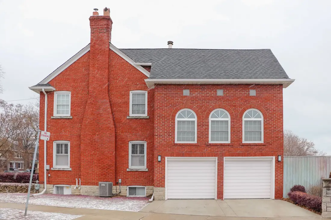 A red brick Iowa house with a tall brick chimney, the kind of masonry chimney that gets flagged when selling a house with a bad chimney