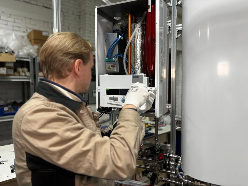 A technician working on a home heating unit, deciding whether to replace a furnace before selling