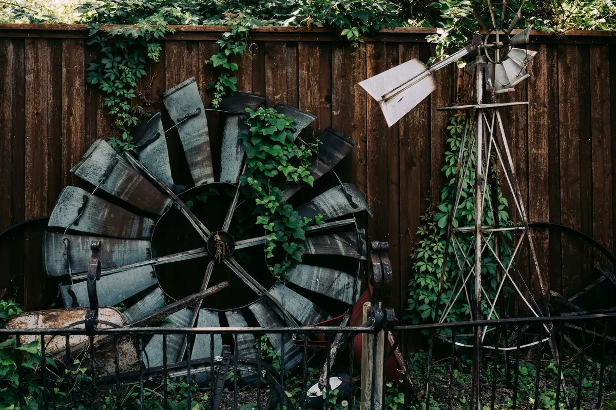 A cluttered pile of old metal and junk stacked against a fence, the kind of view next door that hurts home showings