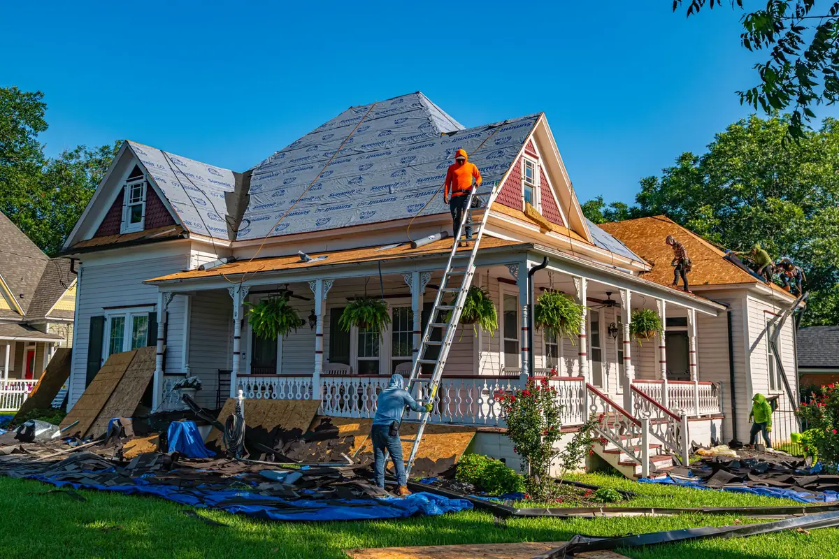 Crews tearing off and replacing the roof on an American home before selling