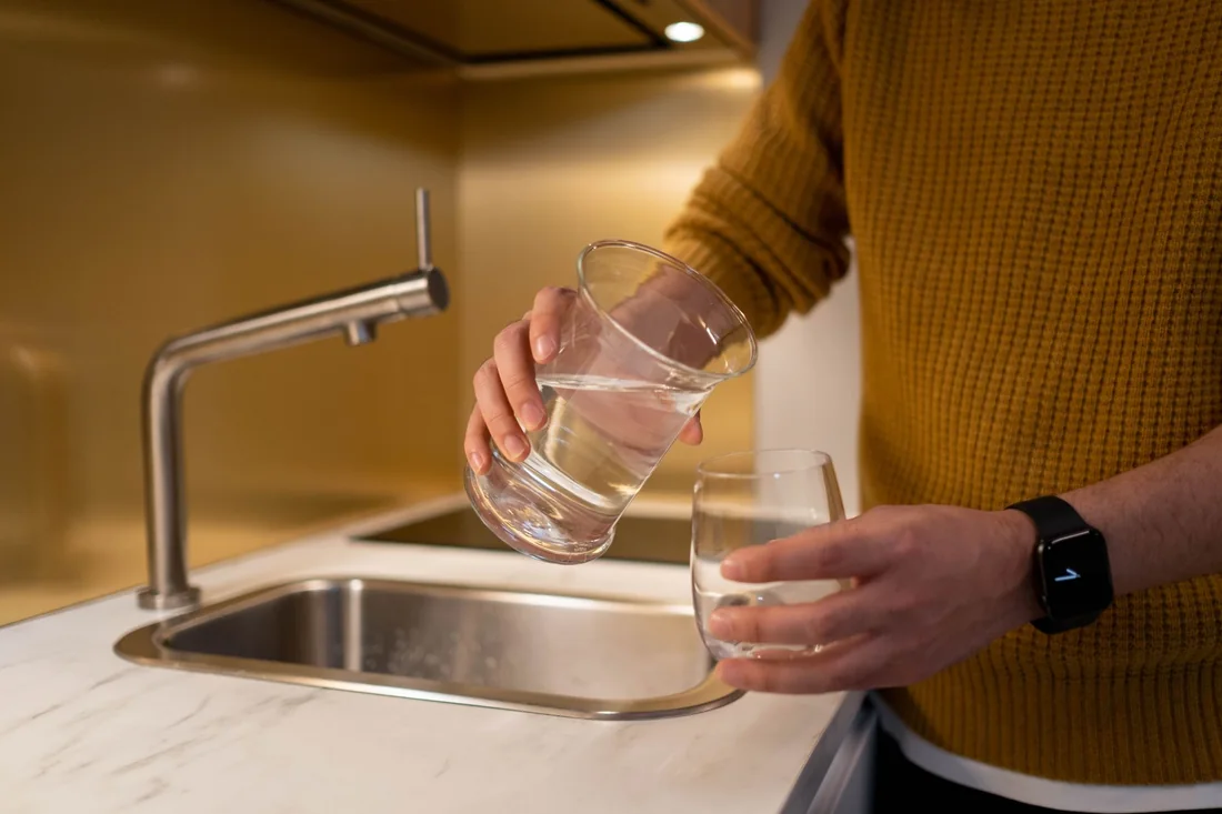 Clear water poured into a glass from a rural tap, the everyday test of selling a house with a bad well in Iowa