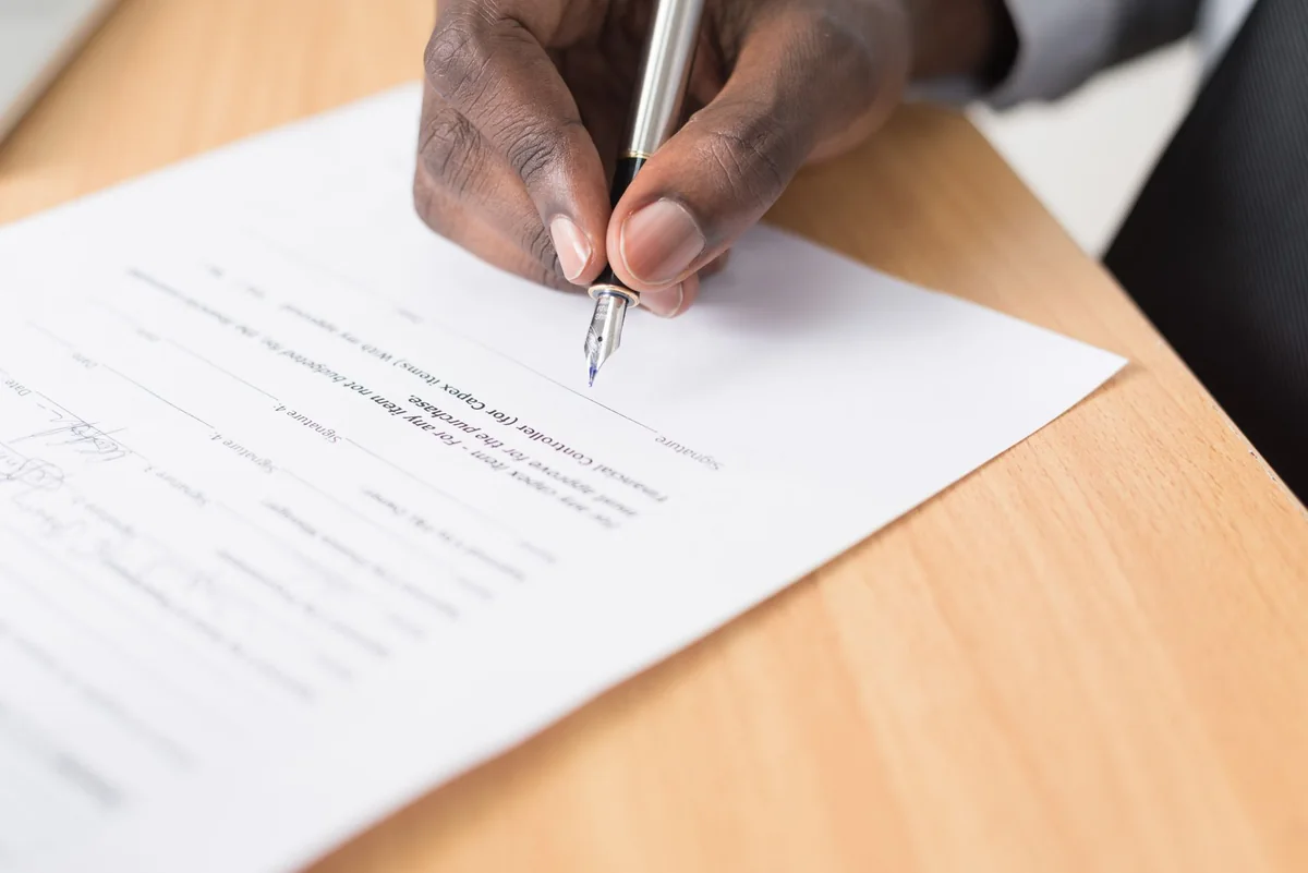 A contract and fountain pen on a desk, representing the options for handling a solar lease when selling a house in Iowa