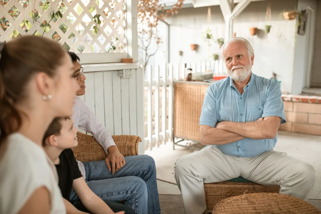 An older parent and adult child talking at home, the two sides of selling a house with a life estate in Iowa