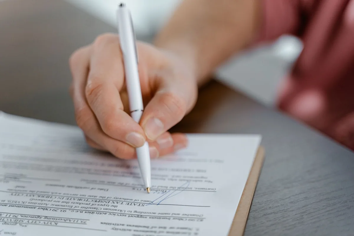 A person signing a legal document, representing a mechanic's lien recorded against an Iowa property
