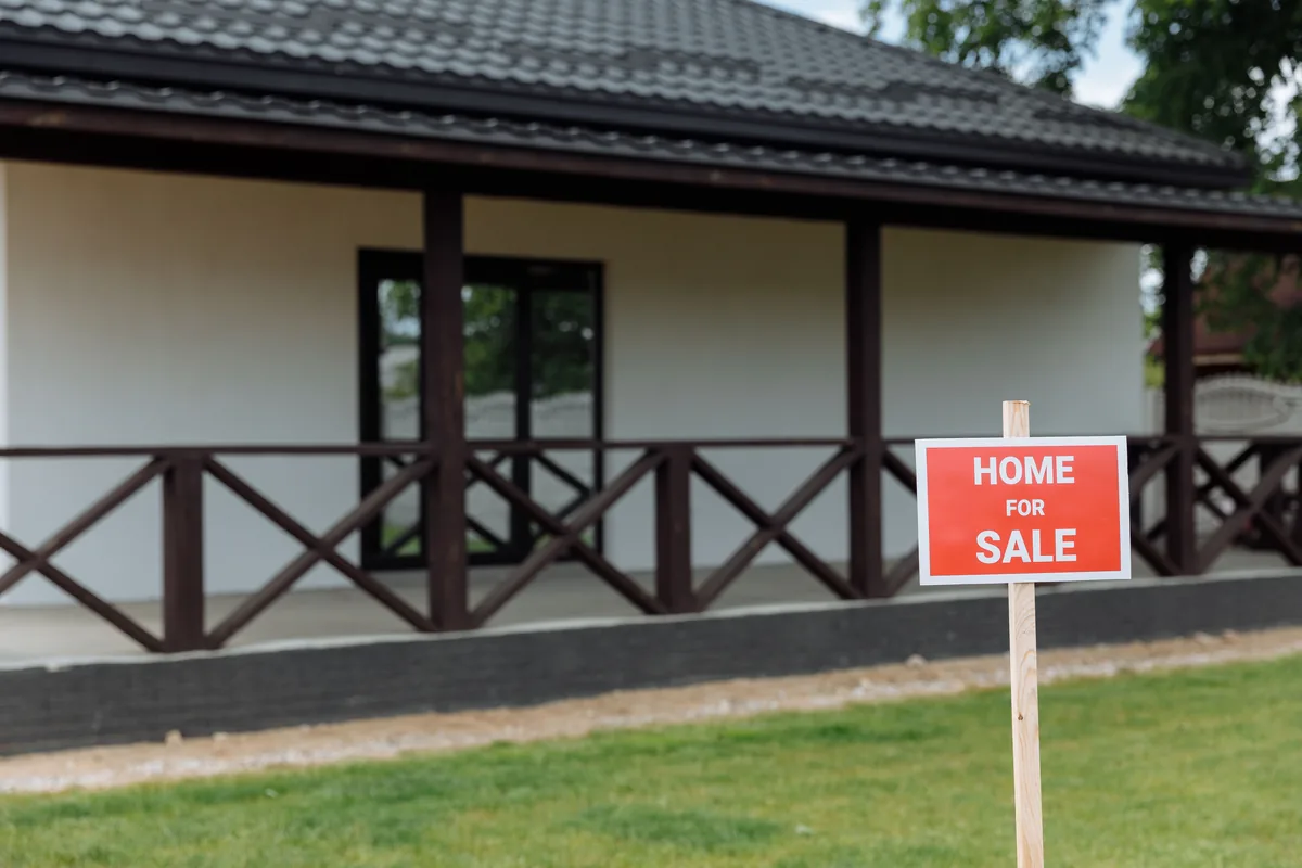 A for-sale sign on an Iowa home affected by mold and financing hurdles