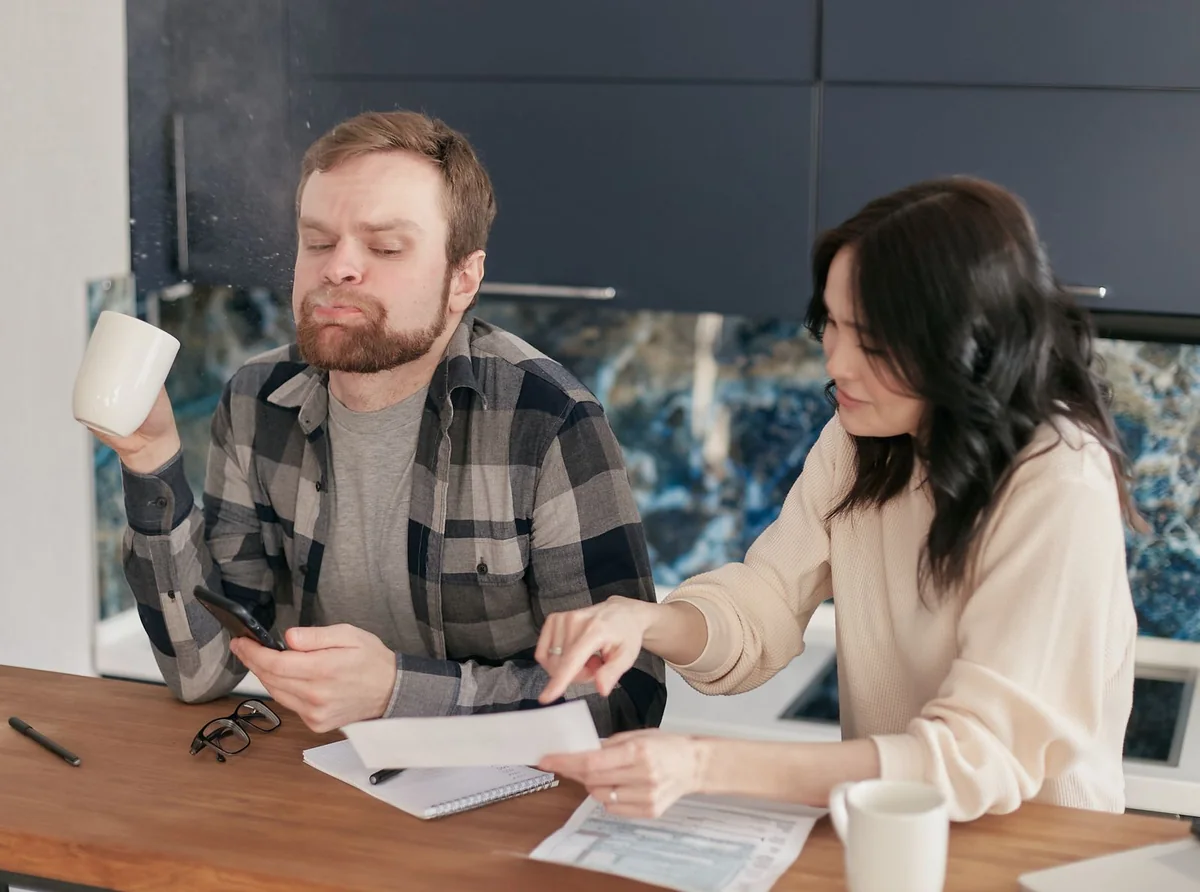 A couple at the kitchen table reviewing bills on a house that's underwater