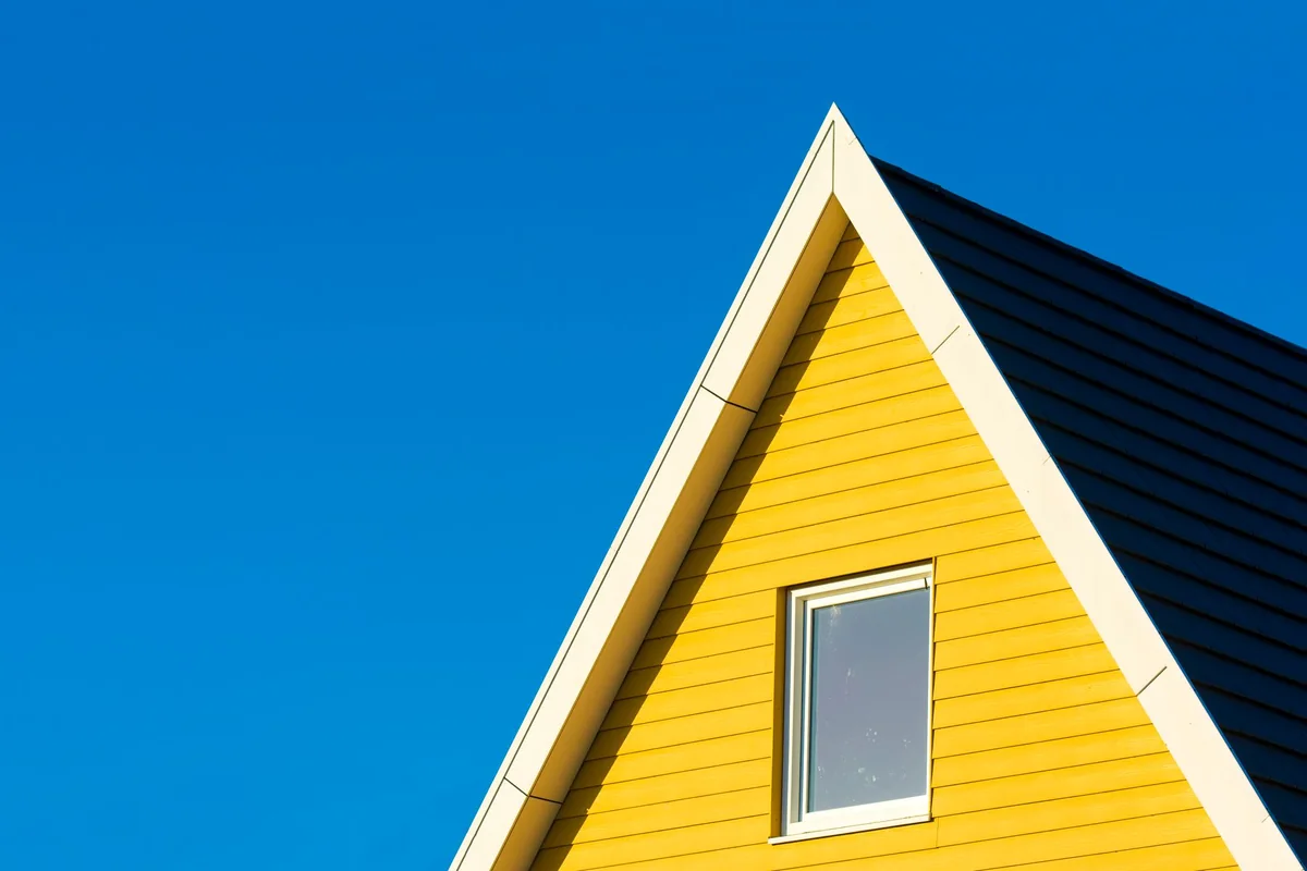 Bright summer sun in a clear sky over a house, when a home with no central air shows at its worst