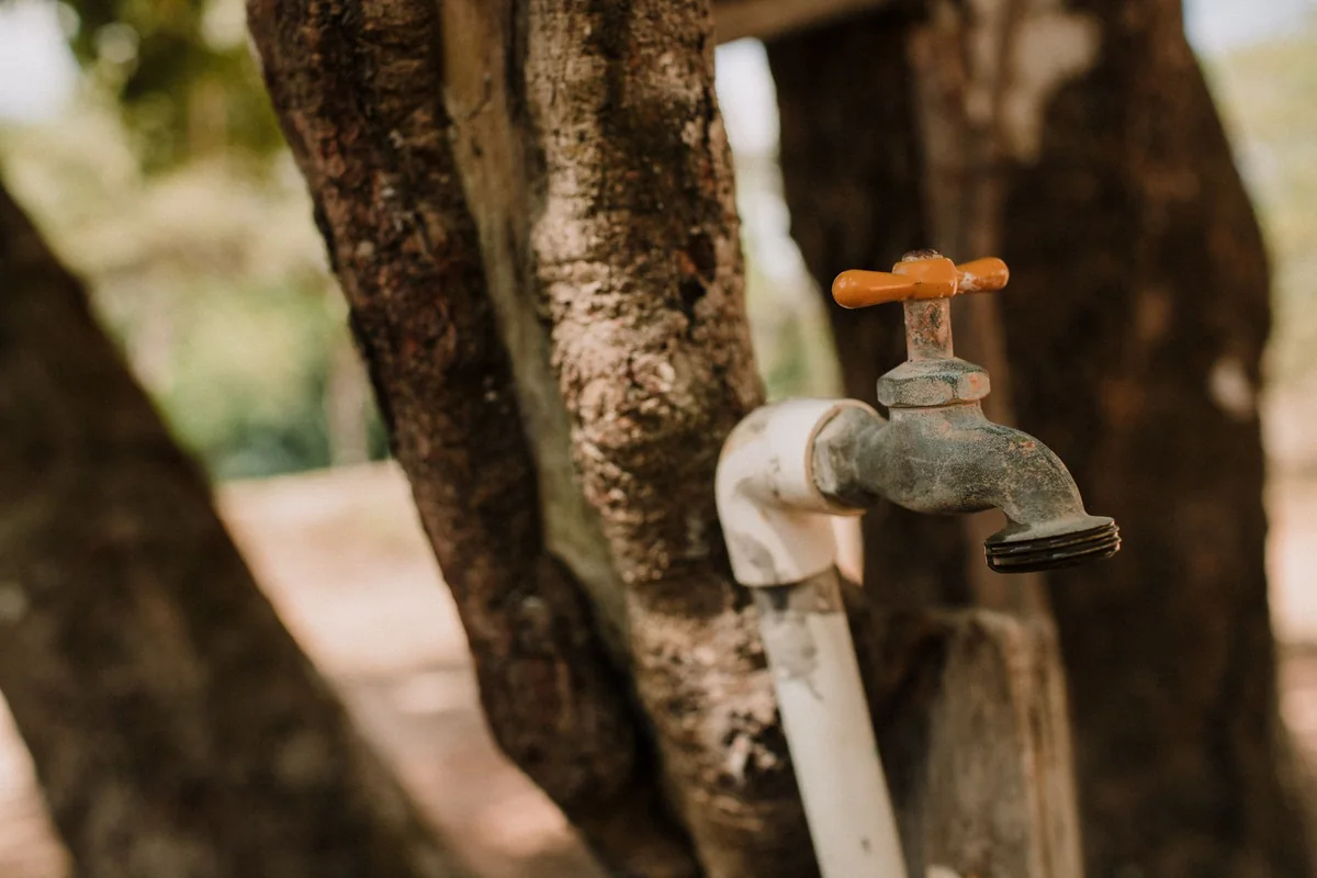 Water running from an old faucet, the low pressure and rusty flow a buyer notices when selling a house with old plumbing in Iowa