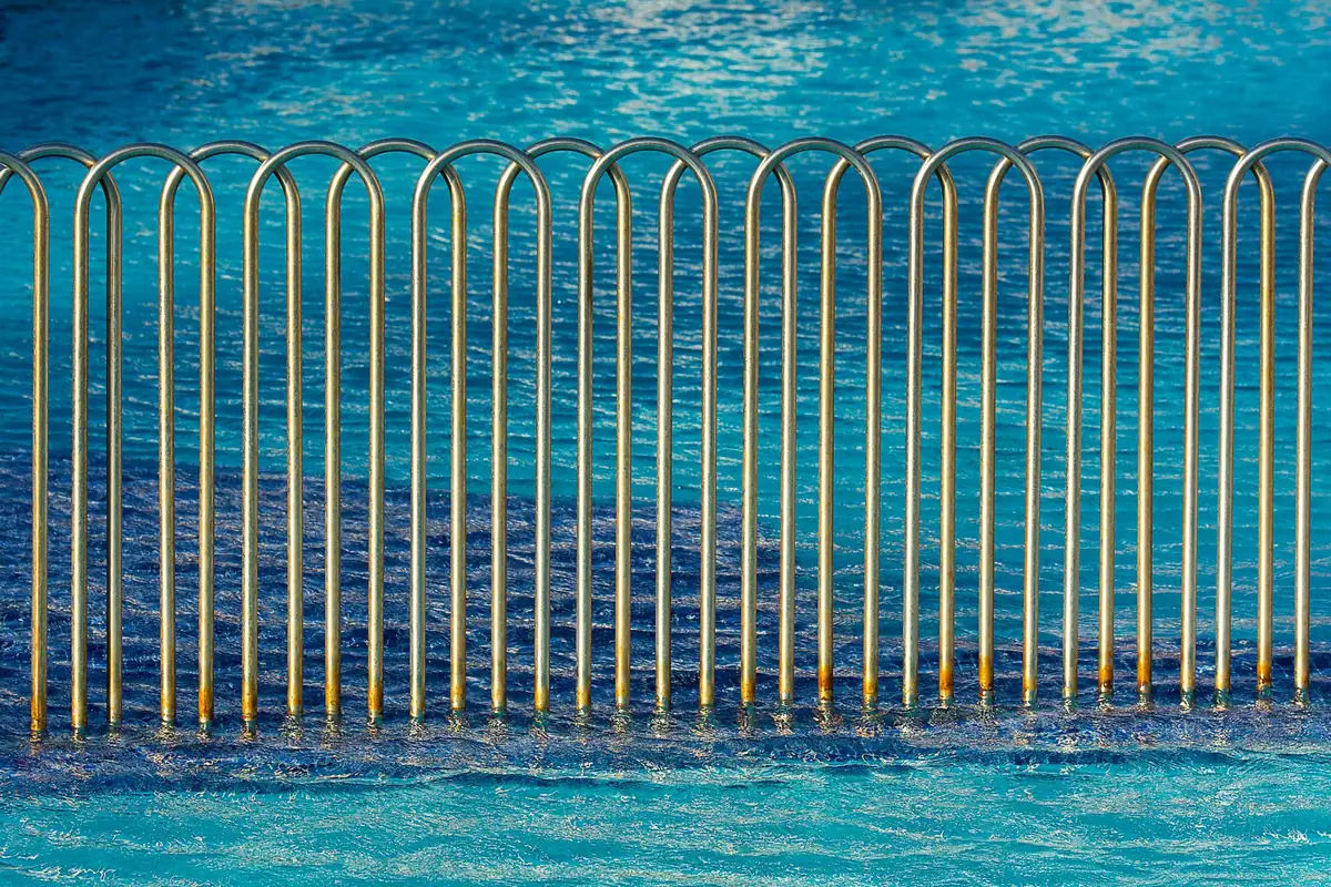 A safety fence and barrier around a swimming pool, the kind insurers may require when selling a house with a pool