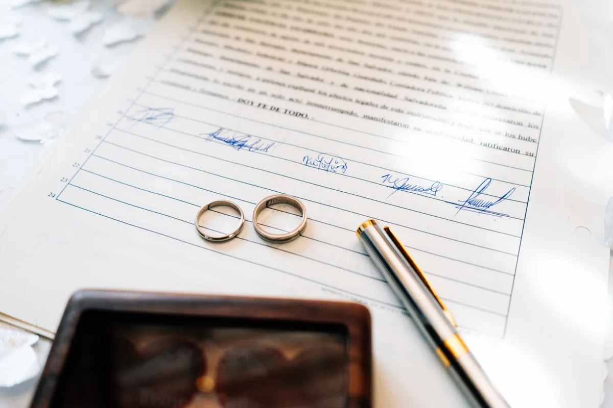 Wedding rings resting on legal documents, a common reason a quitclaim deed is used in a divorce