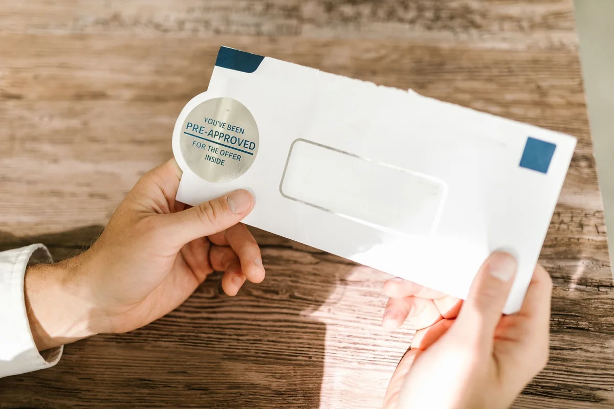 Unopened bills and envelopes stacked on a counter, the kind of second-mortgage statement a seller half-forgets