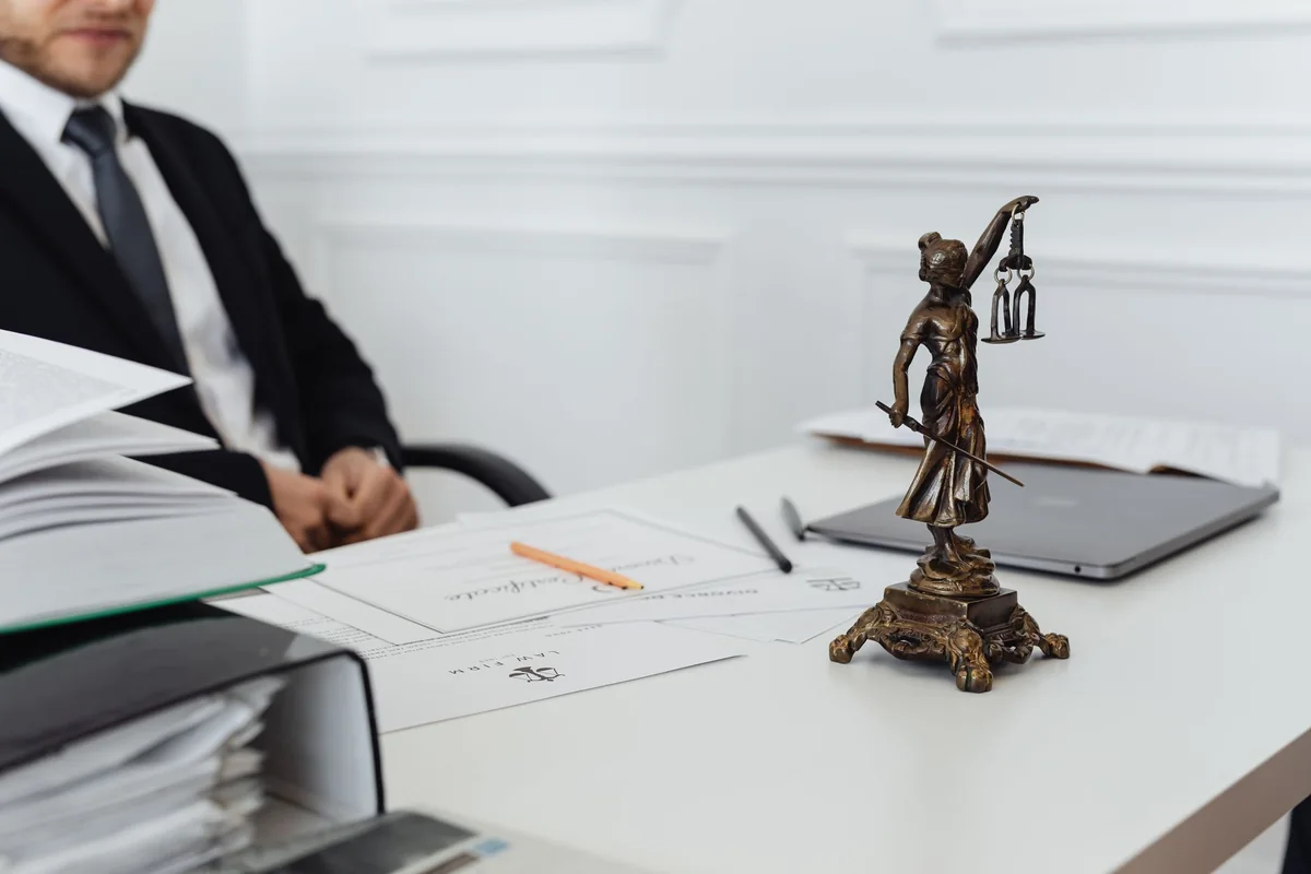 Legal documents and a scales-of-justice figure on a desk, the court process to remove a squatter in Iowa