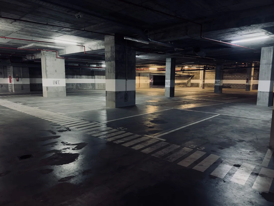 Water pooled across a dark concrete basement floor near a drain, the chronic wet basement to deal with before selling an Iowa house