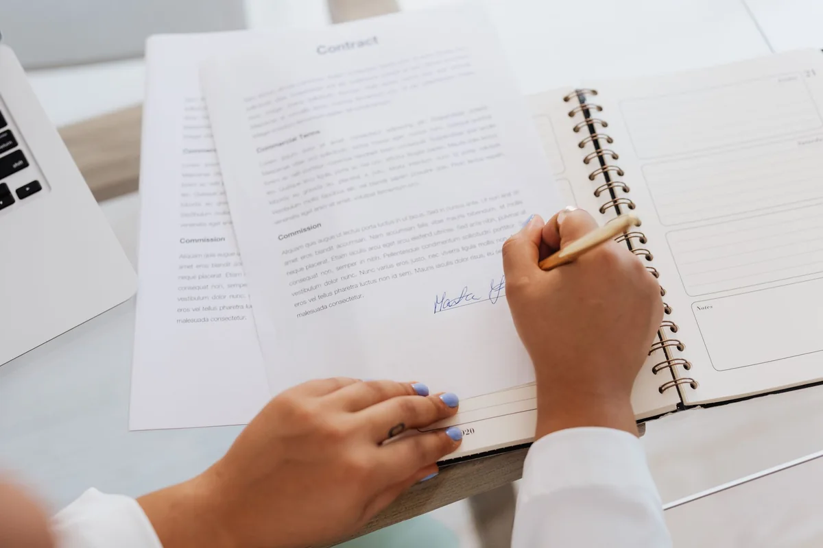 A person signing court documents during Iowa probate before selling a parent's house