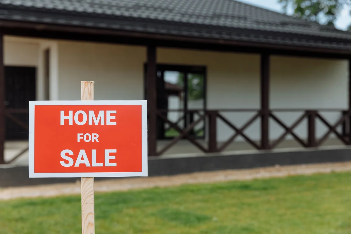 A for-sale sign in the yard of an Iowa home being sold after a parent's death