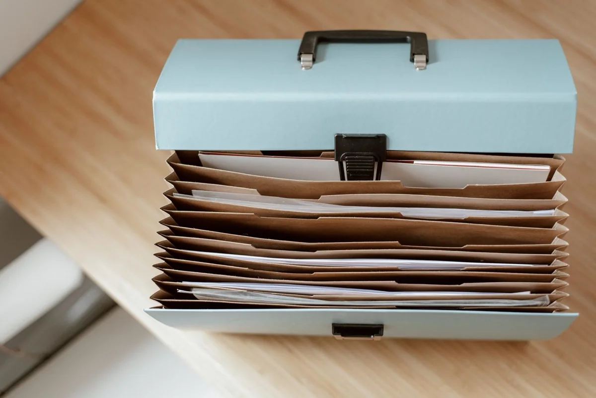 Estate paperwork and a folder of court forms for selling a house in probate