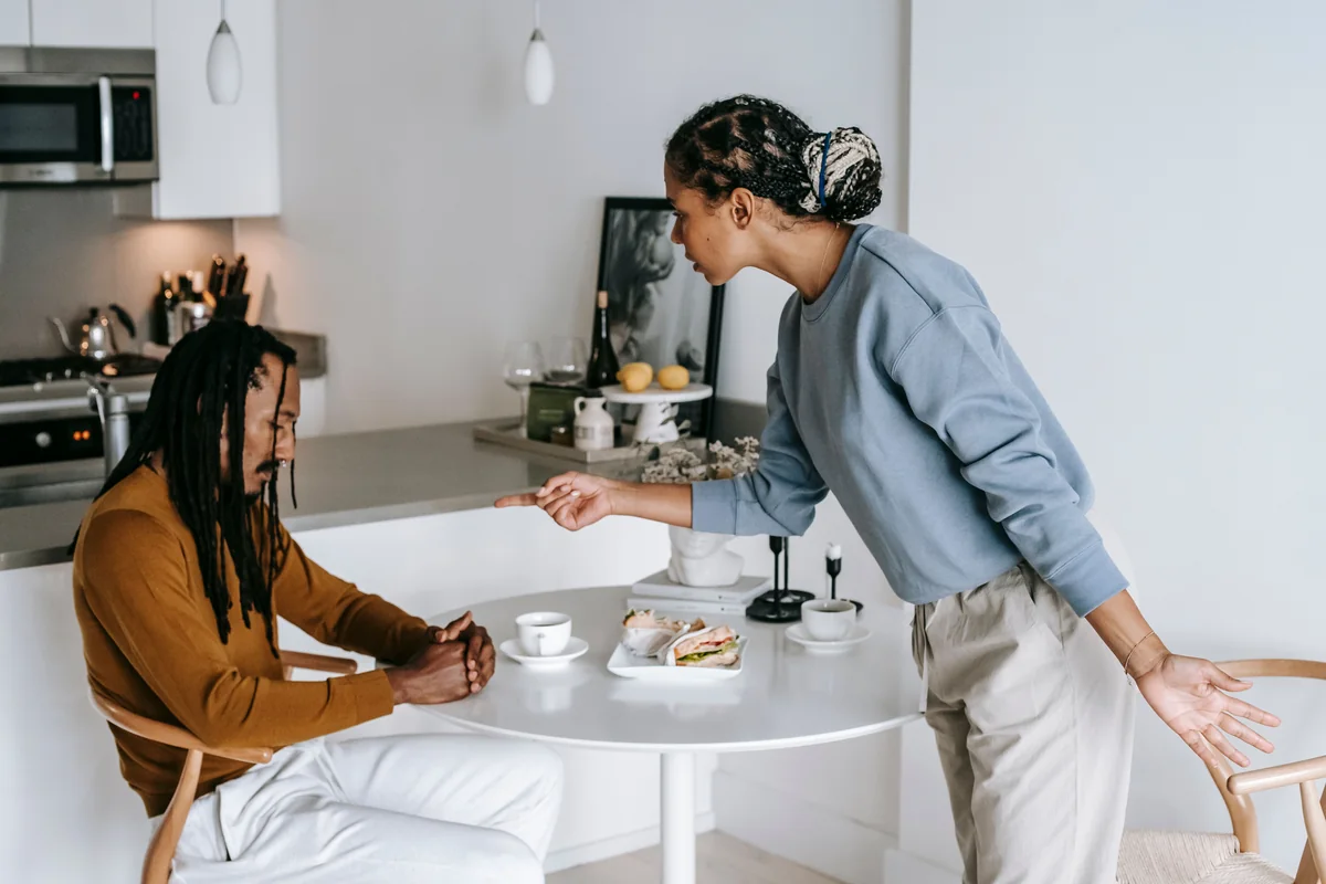 Siblings disagreeing at a kitchen table about an inherited house