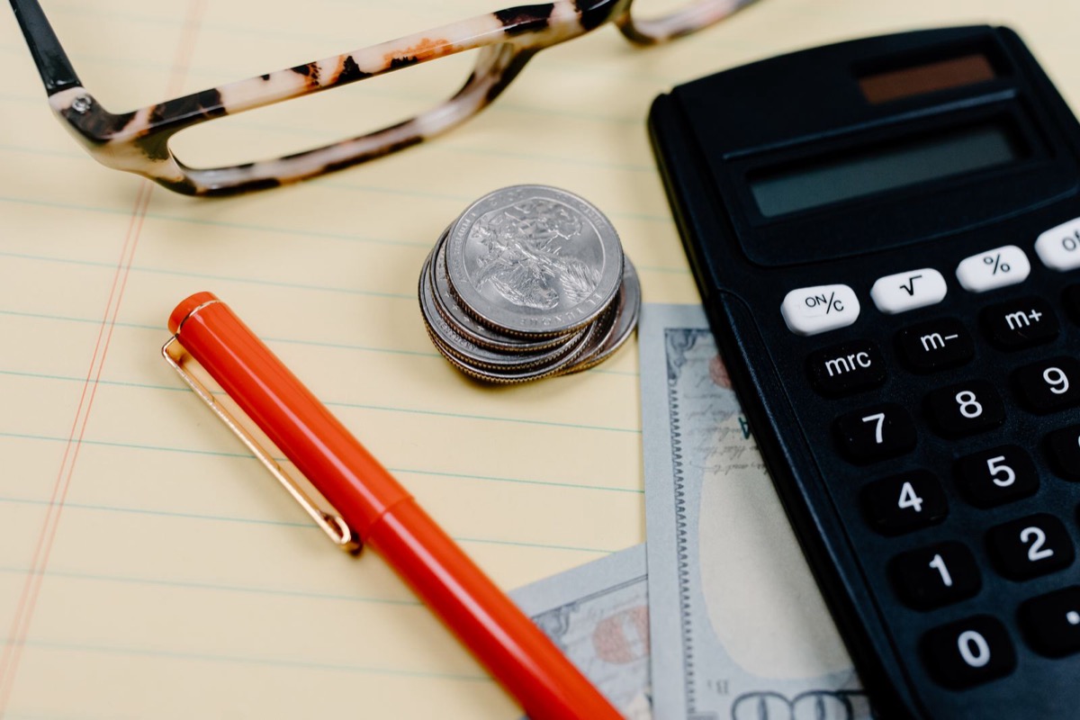 A calculator and small house model representing the capital gains home-sale exclusion