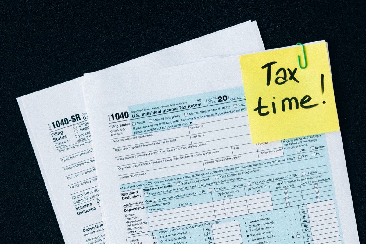 A 1040 tax form and paperwork on a desk for figuring gain on a home sale